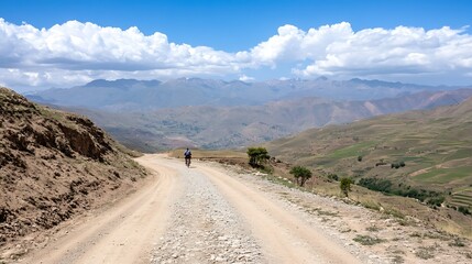Aufkleber - A scenic dirt road winding through the mountains under a bright blue sky with beautiful clouds capturing the essence of adventure : Generative AI