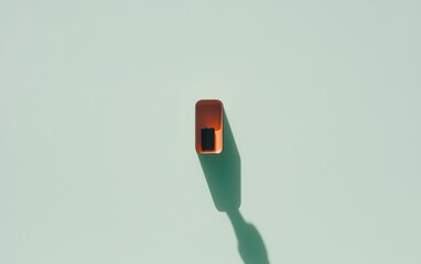Poster - Overhead shot of a small, rectangular orange object casting a shadow on a pale green background. Minimalist and simple composition