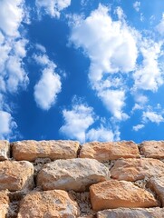 Poster - Clear blue sky with fluffy clouds above a rustic stone wall creating a picturesque scene : Generative AI