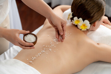 woman customer having exfoliation treatment in luxury spa salon with warmth candle light ambient. sa