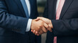 © saichon - Business handshake between two men in suits, symbolizing agreement and partnership