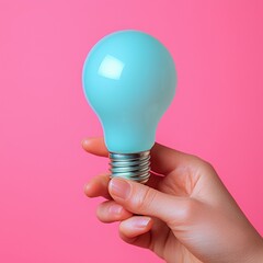 Poster - Hand holding a brightly lit light bulb symbolizing ideas and innovations against a soft background