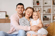 © Pixel-Shot - Happy parents with their little daughter hugging on sofa at home