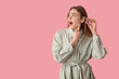 © Pixel-Shot - Beautiful young woman pointing at hearing aid on pink background