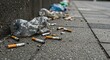 © IbragimovN - Urban pollution: cigarette butts and plastic bottles littering a city sidewalk