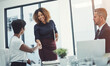 © peopleimages.com - Happy, business people and meeting with handshake for greeting, deal or agreement together in boardroom. Employees, coworker or colleagues shaking hands in conference with smile for new recruit