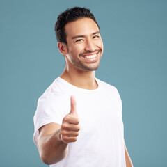 Poster - Portrait, happy and man with thumbs up in studio for yes, thank you sign and feedback on news. Smile, male person and hand gesture of agreement, like opportunity and celebrate vote on blue background