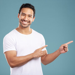 Aufkleber - Portrait, man and smile pointing in studio of presentation, announcement news and information. Happy, male person and hand gesture for coming soon, sign up timeline and opportunity on blue background