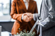 © Phushutter - Two businesswomen shake hands at desk, finalizing deal on property development. real estate investments, zoning laws, sustainable energy solutions while working on city tower model, net-zero goals.