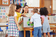 © peopleimages.com - Education, woman and kids in classroom, smile and project for earth day, recycle and knowledge. Child development, happy students and educator with creativity, eco friendly lesson or growth in school