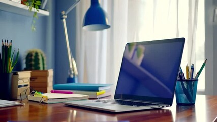 Poster - Modern Home Office Setup with Laptop on Wooden Desk, Surrounded by Stationery, Books, and Blue Desk Lamp, Creating Productive and Organized Workspace
