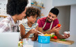 © NDABCREATIVITY - Happy black family in the kitchen having fun and cooking together. Healthy food at home.