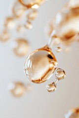 Poster - Droplets of molten amber hang gracefully in mid-air, glowing softly and reflecting light. The blurred background transitions into neutral tones, enhancing the elegance of the scene