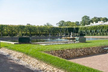 Aufkleber - Exploring the serene gardens of Peterhof with fountains and lush greenery on a clear day