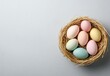 © Kettisak - Pastel Easter Eggs in Bird Nest on Gray Background
