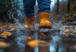 © Micro - Person in Yellow Rain Boots Splashing Through a Puddle with Autumn Leaves