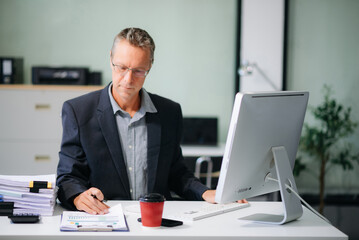 Mature business man executive manager looking at laptop watching online webinar training or having virtual meeting