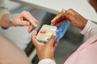 © Seventyfour - Close-up of two people sharing and organizing medications from a pill organizer. The elderly person's hand reaching for the pill emphasizes caregiving