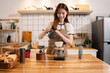 © NINENII - Lifestyle people, Happy woman making drip coffee in the kitchen.