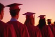 © Ivan - Graduates in caps and gowns stand united against vibrant sunset