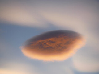 cotton wool-shaped lenticular cloud framed by mother-of-pearl clouds