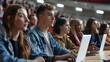© Studicon - A group of students are sitting in a classroom and using laptops