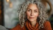 © AlirezA - Radiant older woman with natural gray curls confidently posing in front of a mirror in a cozy indoor setting