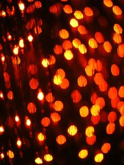 Poster - Vibrant amber lights illuminate a dark backdrop creating a bokeh effect