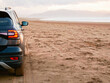 © mark_gusev - Car on a sandy Inch beach, county Kerry, Ireland, Stunning Irish nature scenery in the background. Travel by renting car concept. Cloudy sky. Popular famous tourist area. Fun driving on sand.