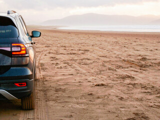 Wall Mural - Car on a sandy Inch beach, county Kerry, Ireland, Stunning Irish nature scenery in the background. Travel by renting car concept. Cloudy sky. Popular famous tourist area. Fun driving on sand.