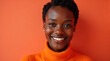 © Happiness  Factory - Close-up portrait of a smiling young Black woman against a vibrant orange background. Ideal for projects related to beauty, fashion, and positive emotions.