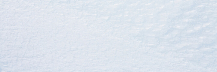 Wall Mural - Natural snow texture. Smooth surface of clean fresh snow. Snowy ground. Winter background with snow patterns. Closeup top view. Wide panoramic texture for background and design.