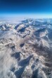 © ANUAR - Majestic Snow-Capped Mountain Range Overlooking Clouds Under Clear Blue Sky, Aerial View of Serene Natural Landscape with Rugged Peaks and Mist