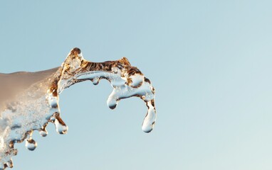Poster - Golden Liquid Splash Against Blue Sky