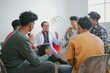 © Gatot - The Caregiver Therapist Sits With Group Of Diverse People In A Circle For Checking Physical And Mental Health On Group Therapy Session