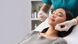 © photostockatinat - cosmetic procedure being performed on a woman. A doctor wearing gloves holds a syringe near the patient's face. The setting is a medical spa or clinic