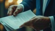 © leymart - Close-up of businessman's hands holding important documents.
