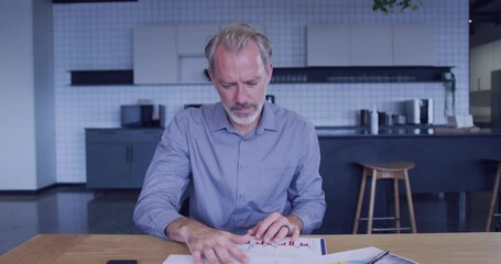 Poster - Man analyzing documents with colorful digital arc animation in modern kitchen