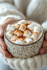 Poster - A person holding a cup of hot chocolate with marshmallows, perfect for a cozy winter scene or holiday treat