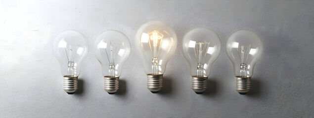 Poster - 5 light bulbs of different sizes, one bulb is lit up and the other four are off