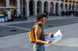 © bernardbodo - Tourist exploring lisbon city center holding a map and smiling