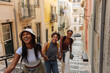 © bernardbodo - Three tourists holding hands are walking down the stairs of lisbon