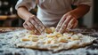 © Jajang - Chef's hands preparing a potato-filled dough.  A close-up view of a chef carefully placing sliced potatoes onto a prepared dough surface, dusted with flour