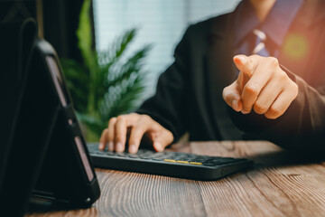 Poster - Professional Businessman Pointing at the Camera While Working on a Laptop in Modern Office Setting, Business concept