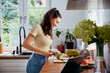 © baranq - Woman chopping vegetables in kitchen for healthy meal