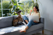 © baranq - Woman having fun with her whippet puppy while working from home
