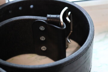Poster - A detailed view of a leather belt featuring a metal buckle.