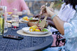 © Wavebreak Media - Senior Friends enjoying outdoor meal together, sharing fresh salad and grilled corn