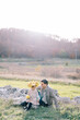 © VolodymyrNadtochii - Little girl in a wreath of yellow leaves sits on a stone next to her dad on the sunny lawn