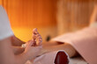© .shock - Foot Massage Therapy in a Relaxing Spa Setting. A professional massage therapist in a white uniform provides a soothing foot massage to a client in a calm and serene spa environment